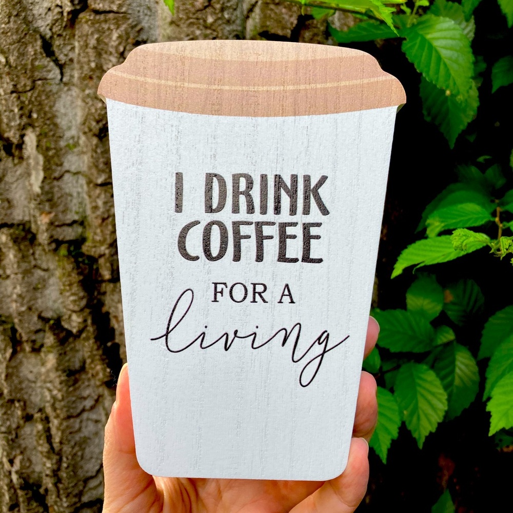 Wooden block sign. Drink coffee for a living.